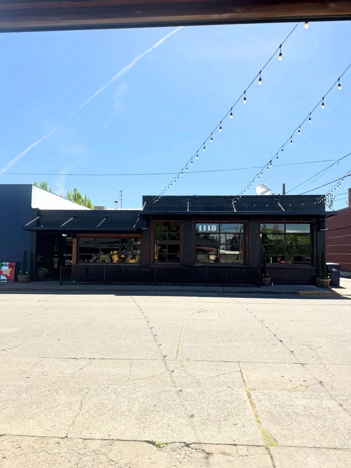 Steel awnings and string lights on the black brick storefront of Il Siciliano's in Enumclaw