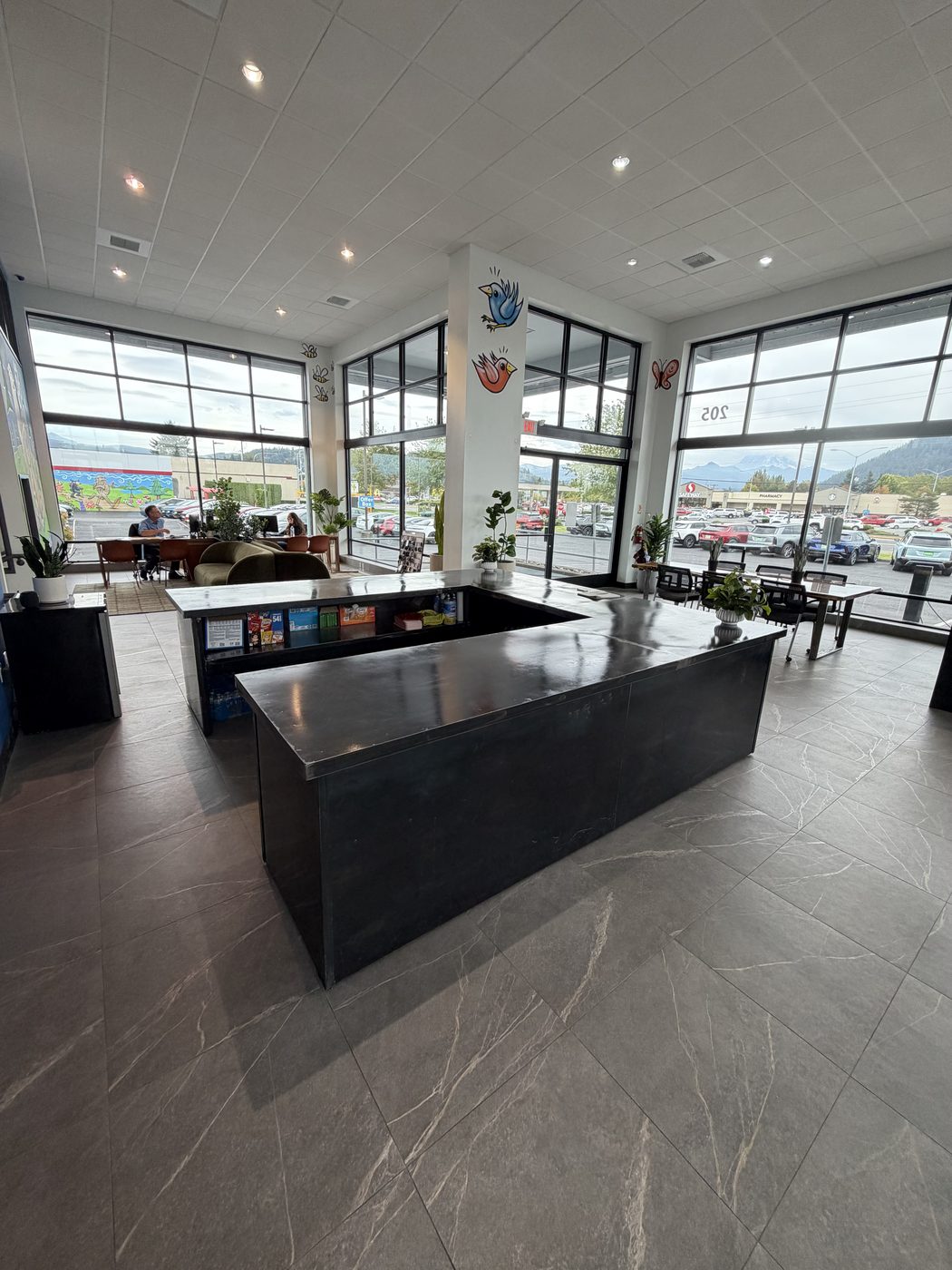 Long black steel front counter in a bright showroom with tall windows