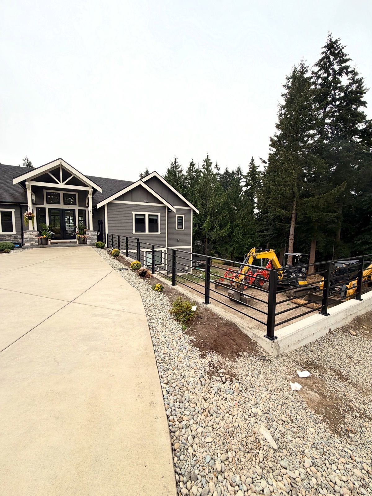 Long horizontal-bar exterior handrail in front of a gray craftsman home
