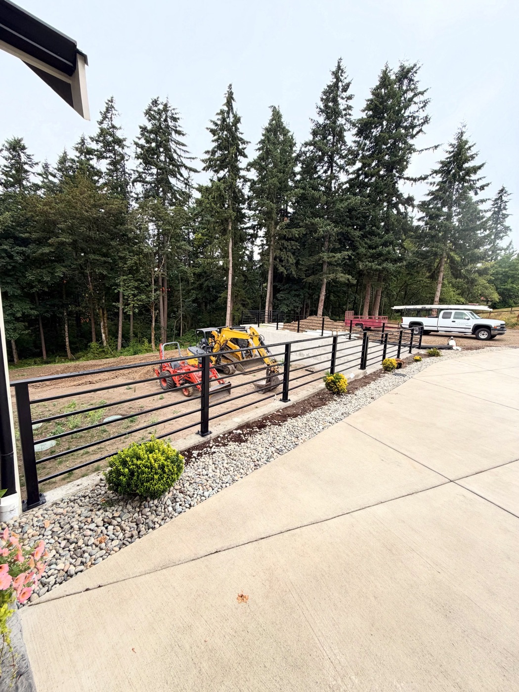 Steel railing along a concrete walkway with the work truck behind